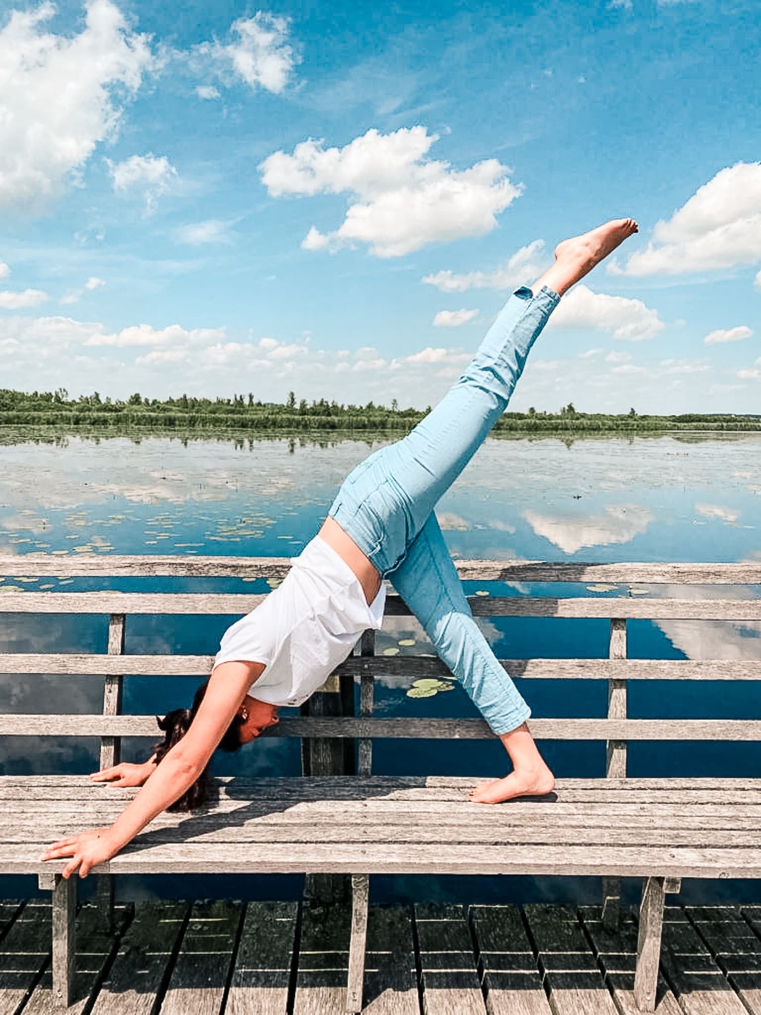 Yoga auf einem Holzsteg an einem ruhigen See